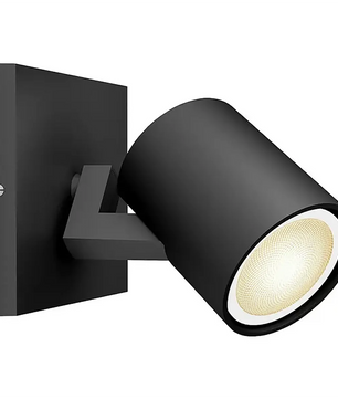 Philips Hue Ambiance Spot Runner LED-Leuchtmittel in mattem Schwarz, wandmontiert mit zylindrischem, schwenkbarem Kopf, eingeschaltet und Licht ausstrahlend; kompatibel mit GU10-LED-Spots oder Philips Hue White Ambiance-Leuchtmitteln für dimmbare Beleuchtung.