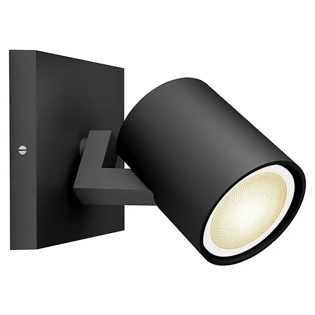 Philips Hue Ambiance Spot Runner LED-Leuchtmittel in mattem Schwarz, wandmontiert mit zylindrischem, schwenkbarem Kopf, eingeschaltet und Licht ausstrahlend; kompatibel mit GU10-LED-Spots oder Philips Hue White Ambiance-Leuchtmitteln für dimmbare Beleuchtung.