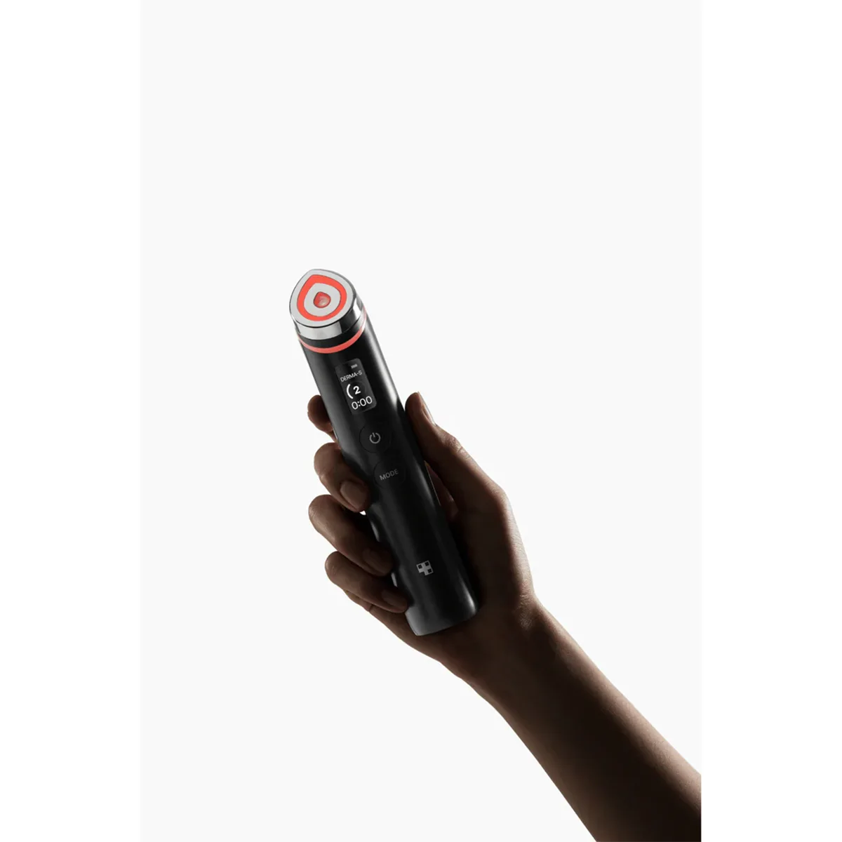 Eine Hand hält den Medicube Age-R Booster Pro von Medicube, ein schwarzes Anti-Aging-Gerät mit einem roten Ring um die runde Spitze, das die Elastizität der Haut verbessern soll, vor einem weißen Hintergrund.