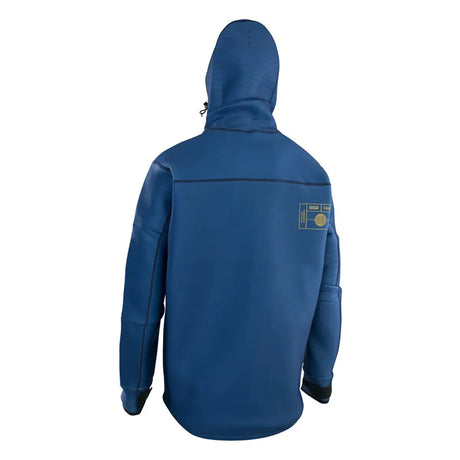 Person, die eine ION Water Neo Shelter Amp Jacke in blau trägt, von hinten gesehen, mit einem kleinen Aufnäher auf der oberen rechten Seite.