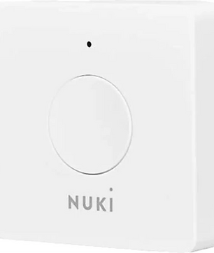 Der NUKI Opener – smarte Zutrittslösung – weiß ist ein weißes Smart-Home-Gerät mit einer zentralen Taste und einer dezenten Kontrollleuchte über dem Logo, ideal für die sichere Zugangskontrolle in Ihrem Zuhause. Dieses Gerät lässt sich mühelos in Ihre bestehende Gegensprechanlage integrieren und ist vollständig kompatibel mit anderen NUKI-Produkten, darunter auch dem Nuki Opener, und ermöglicht so nahtlose Smart-Entry-Lösungen.