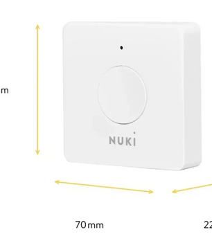 Die weiße „Nuki Opener“ Smart-Zutrittslösung von NUKI ist ein quadratisches Gerät mit den Maßen 70 mm × 70 mm × 22 mm und einem runden Knopf in der Mitte – konzipiert für die nahtlose Integration in Ihre Gegensprechanlage und damit für einen bequemen und sicheren Zugang.