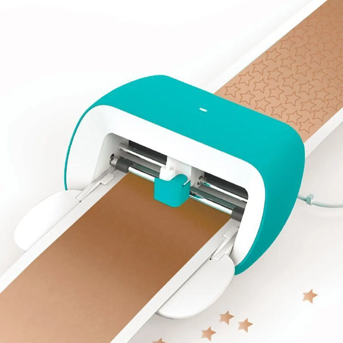 Der Cricut Joy Schneideplotter in türkis/weiß von Cricut schneidet Sternformen auf braunes Papier - ideal für kreative DIY-Projekte.