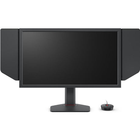 Der BenQ ZOWIE XL2586X eSports-Monitor mit seitlicher Lichtabschirmung ist auf seinem Ständer montiert und wird neben einem kleinen runden kabelgebundenen Controller vor einem weißen Hintergrund gezeigt.