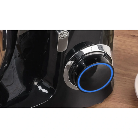 Eine Nahaufnahme der MPM MRK-19 Planeten-Küchenmaschine von MPM mit schwarzem Finish, silbernem und schwarzem, auf Null gestelltem Drehknopf mit blauem LED-Ring, weißer Nummerierung und einem leistungsstarken 2200-Watt-Motor auf einer Holzoberfläche.