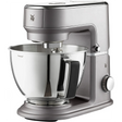 Die WMF KÜCHENminis Küchenmaschine One for All in Grau verfügt über eine Rührschüssel aus Edelstahl mit schwarzem Griff, Bedienknöpfen und Zifferblatt. Auf der Vorderseite befindet sich das WMF Logo, das das stilvolle Design der Marke WMF widerspiegelt.