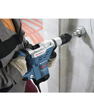 Eine Person verwendet einen Bosch GBH 5-40 DCE Professional Bohrhammer mit SDS-max von Bosch mit einem Lochsägebohrer, um in eine Betonwand zu bohren.