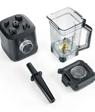 Der CASO Power Blender B 2000 mit seinem durchsichtigen Krug mit Klinge, dem schwarzen Stampfer, dem Deckel und dem Sockel von CASO ist auf einer weißen Fläche angeordnet.