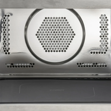 Nahaufnahme der CASO HCMG 25 Mikrowelle - silber interior: 25-Liter-Garraum aus Edelstahl mit sechseckigen Lüftungsschlitzen und Perforationen für die Luftzirkulation, ideal für eine verbesserte Heißluftfunktion. Die Backofentür ist unten teilweise geöffnet. Marke: CASO.