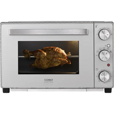 Ein ganzes Brathähnchen auf einem Grill mit Drehspieß im CASO TO 32 SilverStyle Mini-Backofen von CASO (silber) mit Drehreglern und Umluftfunktion.