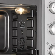 Nahaufnahme des CASO TO 32 SilverStyle Mini-Backofen in Silber von CASO, mit Innenbeleuchtung, Lüfter für Umluftfunktion und Bedienknöpfen auf der rechten Seite.