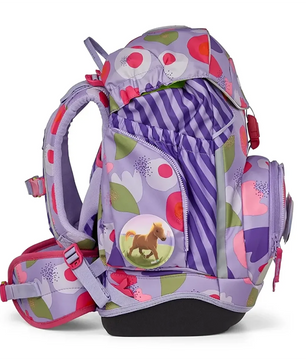 Der ergobag Ergobag Pack Schulranzen-Set 6tlg-BlütenzauBär II ist ein lila und pinkfarbener Kinderrucksack mit Blumenmuster, Pferdeabzeichen und mehreren Taschen, von der Seite gesehen; er verbindet Komfort mit Stil.