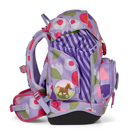 Der ergobag Ergobag Pack Schulranzen-Set 6tlg-BlütenzauBär II ist ein lila und pinkfarbener Kinderrucksack mit Blumenmuster, Pferdeabzeichen und mehreren Taschen, von der Seite gesehen; er verbindet Komfort mit Stil.