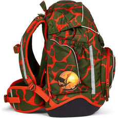 Das ergobag Pack Set (2024) FeuerspeiBär von ergobag ist ein grün-orangefarbener Rucksack mit abstrakten Mustern, reflektierenden Streifen, mehreren Fächern, gepolsterten Trägern, einem Hüftgurt zur Unterstützung und einem runden Dinosaurier-Abzeichen an der Seite.