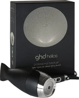 Der ghd helios Haartrockner - Schwarz von ghd steht vor seiner Verpackung mit modernem Runddesign und Branding. Mit innovativer Ionen-Technologie für geschmeidiges, glänzendes Haarstyling.