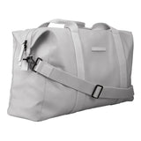 Die Horizn Studios SoFo Weekender M in Light Quartz Grey ist eine nachhaltige Reisetasche aus recycelter Baumwolle mit zwei Henkeln, einem abnehmbaren, verstellbaren Schultergurt und einer seitlichen Reißverschlusstasche, die schräg auf weißem Grund steht.