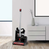 Der INVICTUS X9 Akkustaubsauger in Schwarz steht neben einer weißen Kommode mit grauer Vase und Deko - perfekt für moderne Räume dank HEPA-Filter.