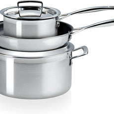 Drei Le Creuset 3 Ply Stainless Steel 3 Piece Töpfe der Marke Le Creuset sind ineinander gestapelt, ein Deckel liegt obenauf. Für Induktion geeignet.