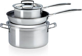Drei Le Creuset 3 Ply Stainless Steel 3 Piece Töpfe der Marke Le Creuset sind ineinander gestapelt, ein Deckel liegt obenauf. Für Induktion geeignet.