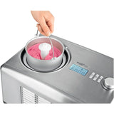 Eine Hand hebt eine Metallschüssel mit rosafarbenem Eis aus der MAXXMEE Eismaschine 150W - silber; ihre Digitalanzeige zeigt 60:00 Minuten an und der 5L-Behälter ist ideal für die Zubereitung großer Mengen.