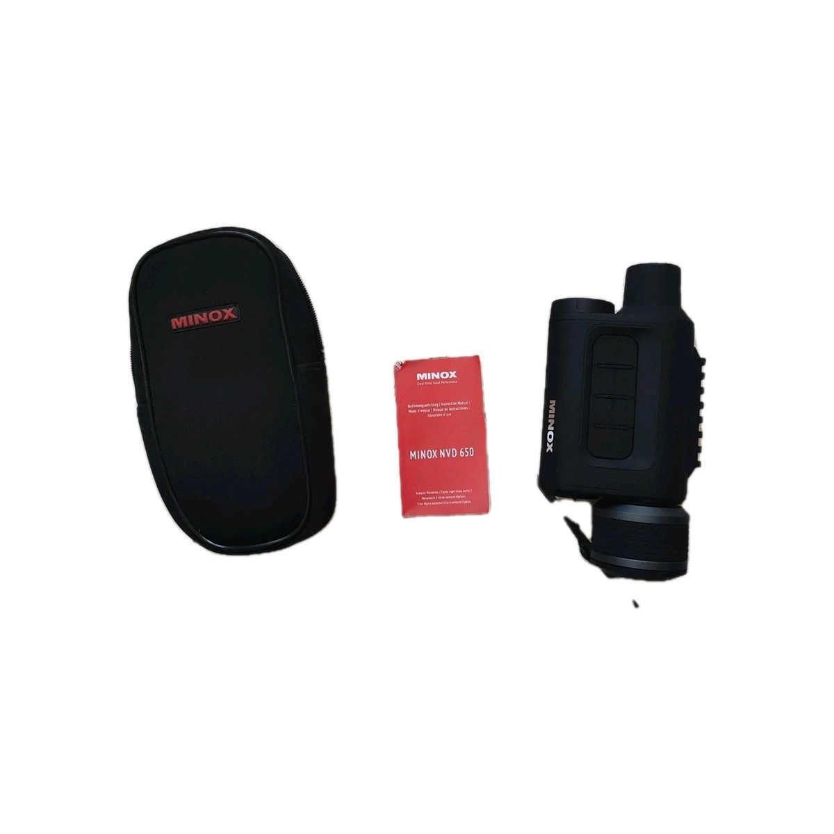 Das Minox NVD 650 Nachtsichtgerät mit Foto- & Videoaufnahme, 30x Vergrößerung, schwarzer Tragetasche, rotem Handbuch und dem kompakten Gerät - alles auf weißem Hintergrund arrangiert.
