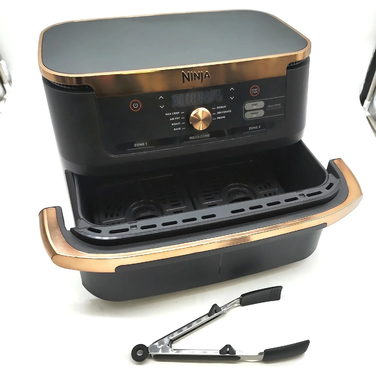 Eine schwarz-goldene Ninja Foodi FlexDrawer Dual Zone Heißluftfritteuse von Ninja mit zwei 4-Liter-Körben wird mit einer Metall-Küchenzange davor gezeigt.