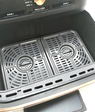 Offene Frittierschublade mit zwei herausnehmbaren Grillschalen im Inneren, die die Vielseitigkeit der Ninja Foodi FlexDrawer Dual Zone Heißluftfritteuse von Ninja mit einem Fassungsvermögen von 4 l unterstreicht.