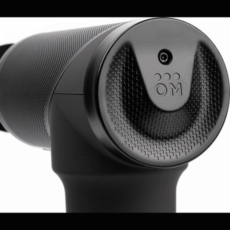 Nahaufnahme der Ortho Mechanik OrthoGun 3.0 Massagepistole von OrthoMechanik mit strukturiertem Griff und kreisförmigem Kopfdesign - ideal für Muskelentspannung und Erholung.