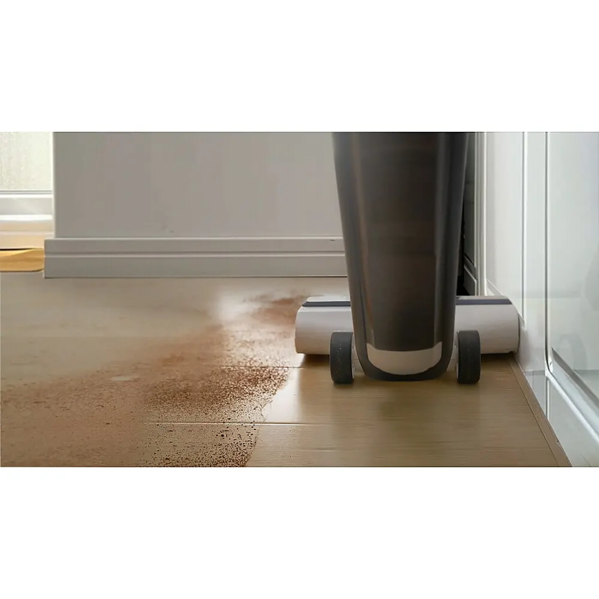 Der TINECO Nass-Trocken-Sauger iFLOOR 5 von TINECO entfernt Schmutz von Holzböden entlang der Wand und sorgt für eine sichtbar saubere Spur.