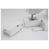 Eine Nahaufnahme der SINGER Nähmaschine "660L Serenade" von SINGER, mit herausgenommenem Zubehörfach und daneben auf einer weißen Fläche.