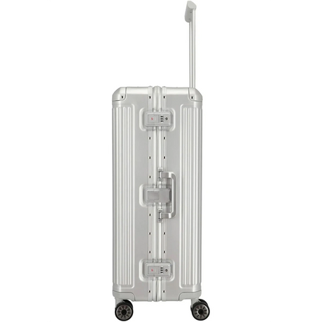Der Travelite Next 4-Rollen-Trolley L (77 cm, Silber) von Travelite ist von der Seite abgebildet und verfügt über einen silbernen Aluminium-Hartschalenkoffer, einen Teleskopgriff und vier Rollen.