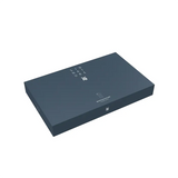 Eine schlichte, rechteckige, dunkelblaue Box mit "SIGNATURE" und weißem Logo auf dem Deckel präsentiert das WMF DECO Besteck-Set 30-tlg Edelstahl by WMF vor einem schlichten weißen Hintergrund.