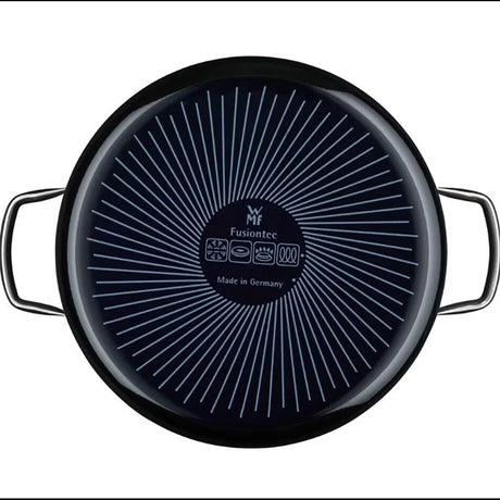 Eine WMF SCHMORPFANNE FUSIONTEC 28 cm in schwarz wird von oben betrachtet und zeigt ihren Boden mit strahlenden weißen Linien, zwei Metallgriffe sowie die Logos WMF und Fusiontec Made in Germany.